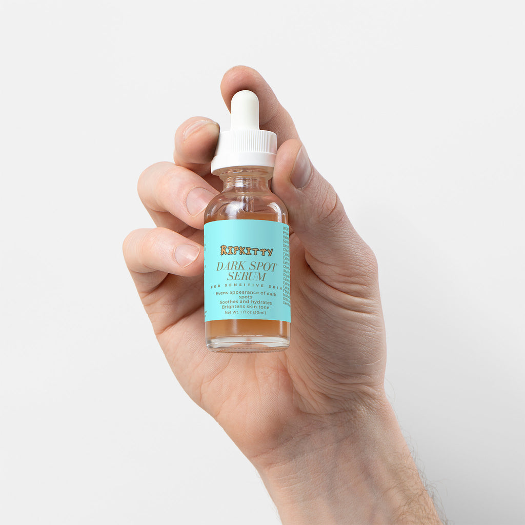 Hand holding a bottle of Kiehl's Dark Spot serum against a light background