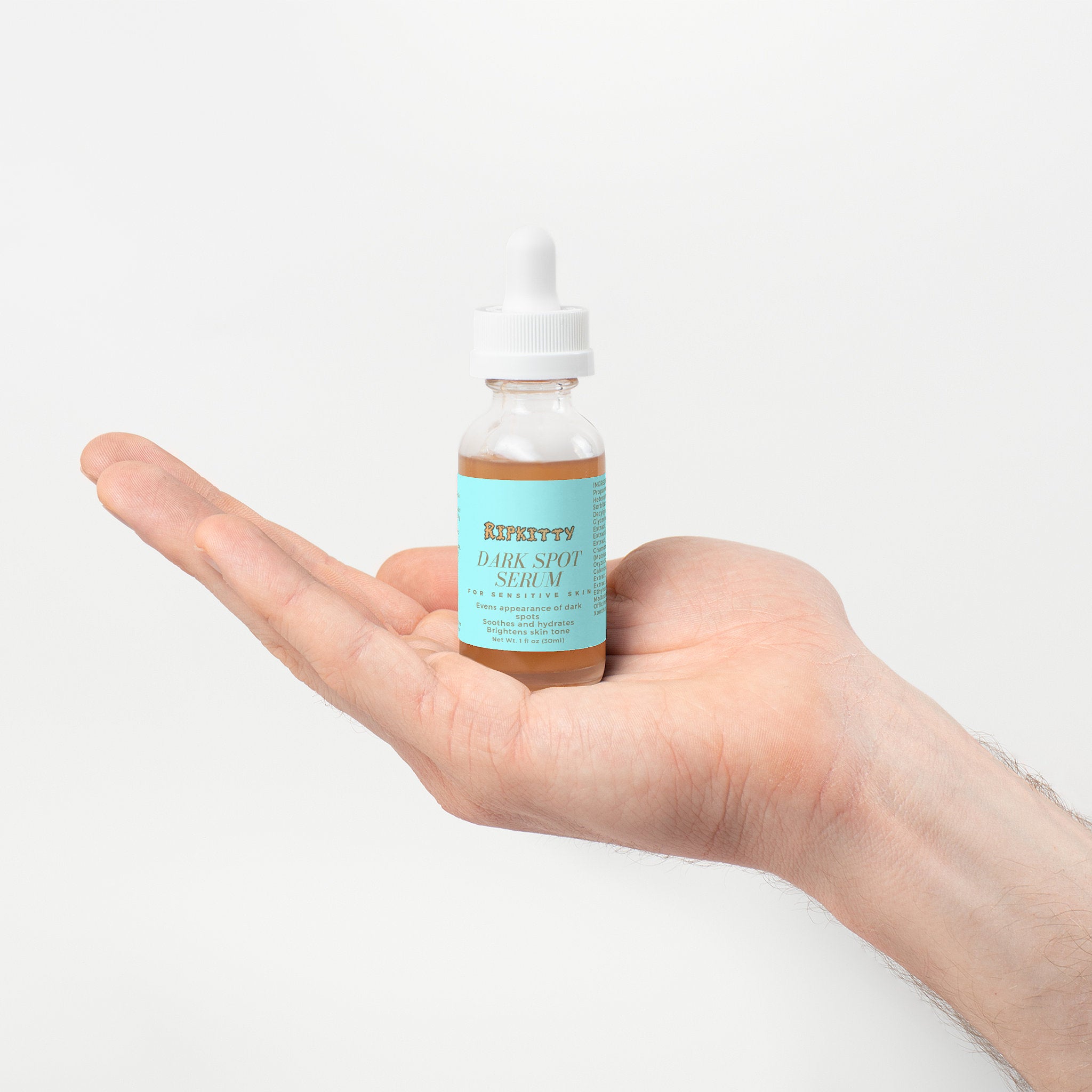 Hand holding a bottle of Kiehl's Dark Spot Serum against a white background