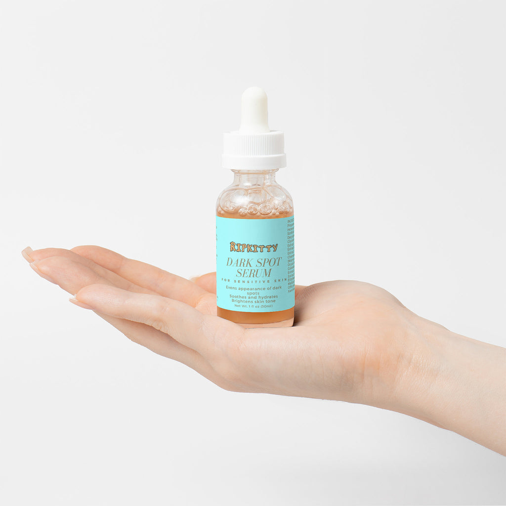 Hand holding a bottle of 'Kieffery' dark spot serum against a light background