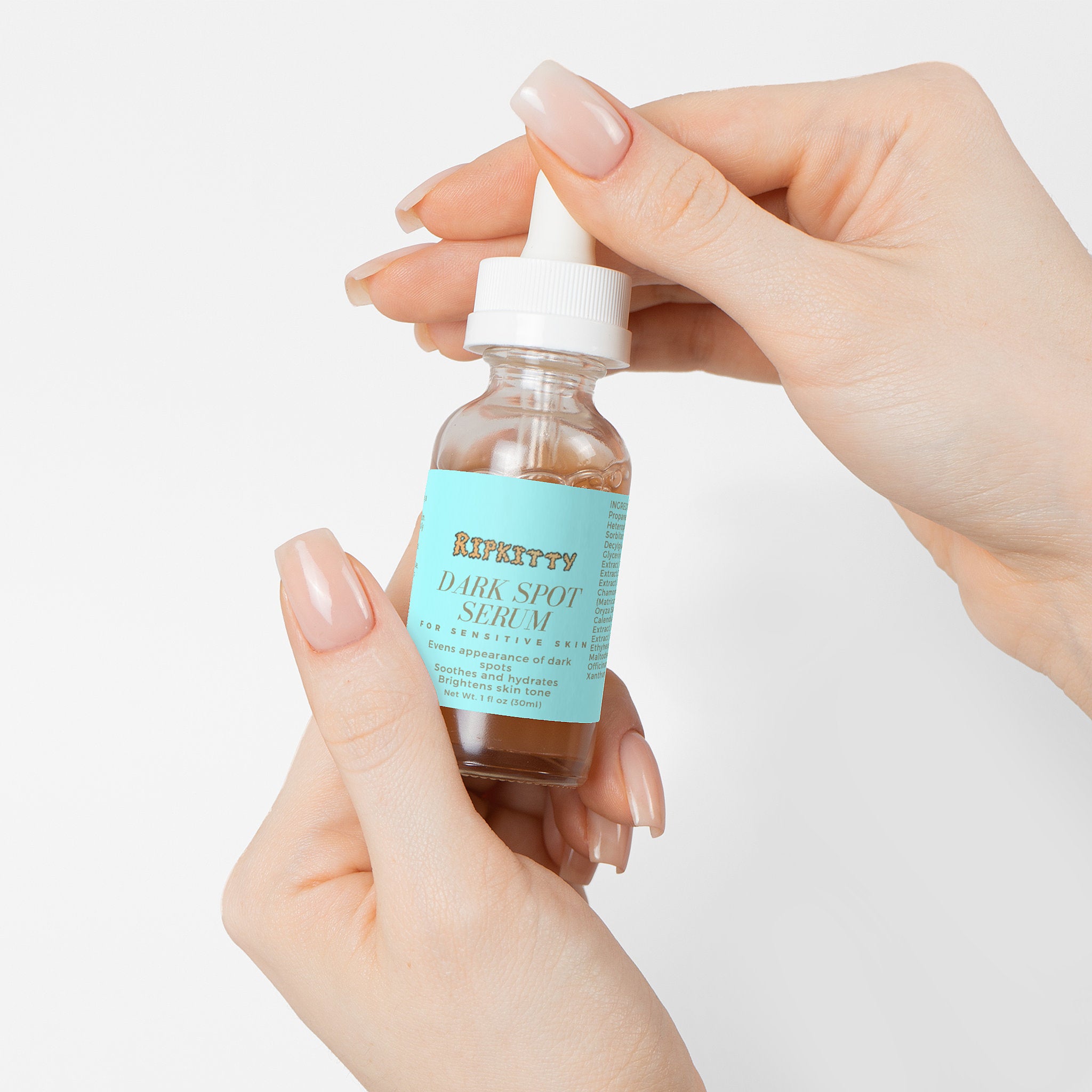 Bottle of dark spot serum held by a hand with a light background