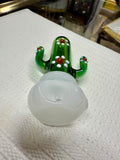 Ripkitty 4.5" cactus borosilicate glass spoon pipe — green sculpted saguaro cactus body with raised white dot nodules and red glass bead accents, large milky white opal bowl, shown on white surface with mirror tray background