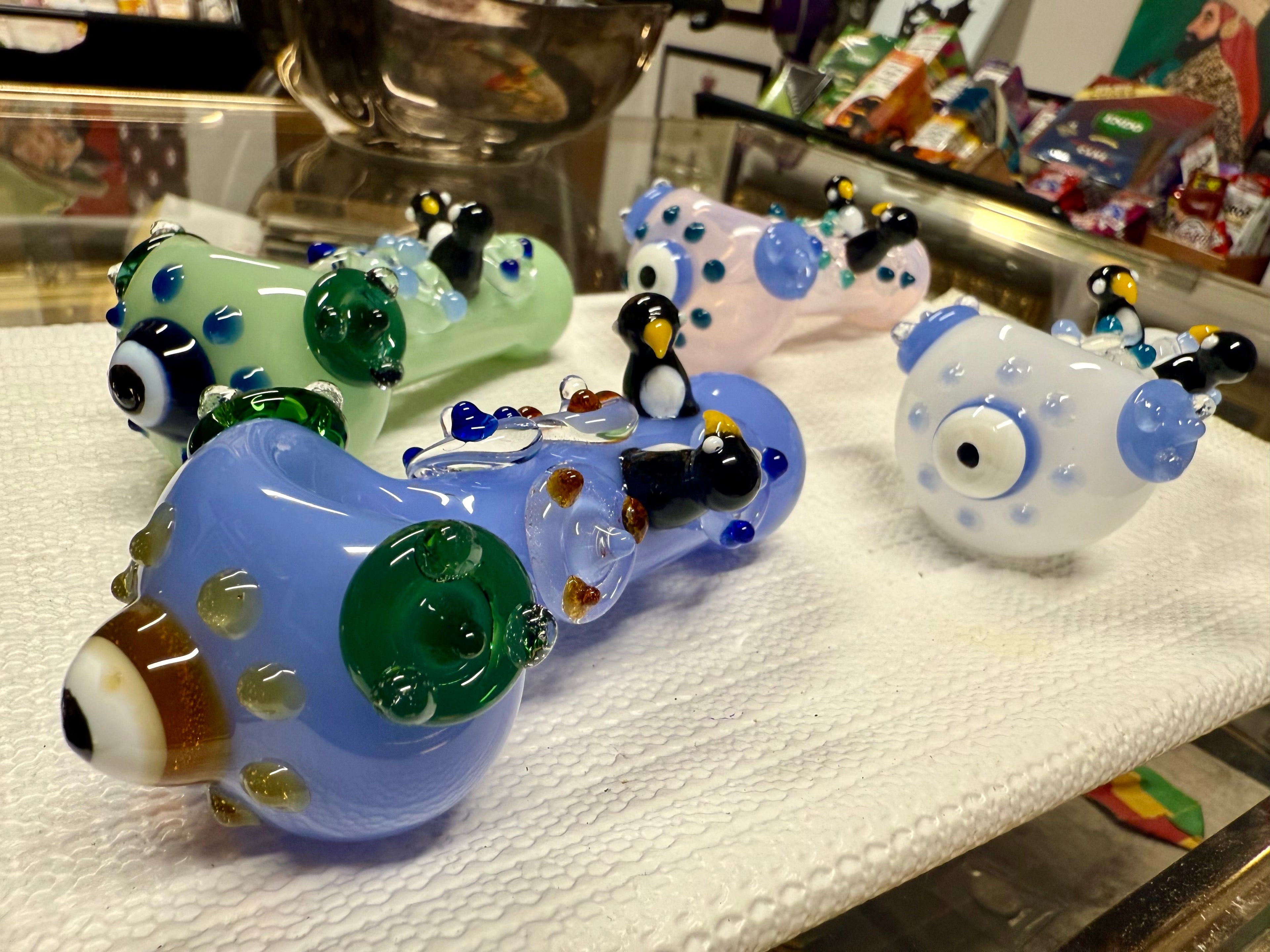 Ripkitty penguin art glass pipe — angled side view showing penguin sculpts and full pipe profile