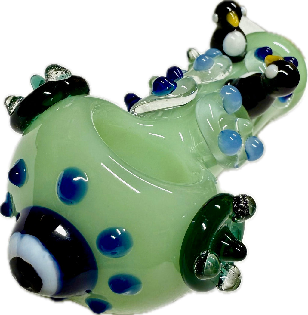 Ripkitty penguin art spoon pipe — mint green, side profile showing full length diagonal from mouthpiece to bowl with penguin figures and flipper accents