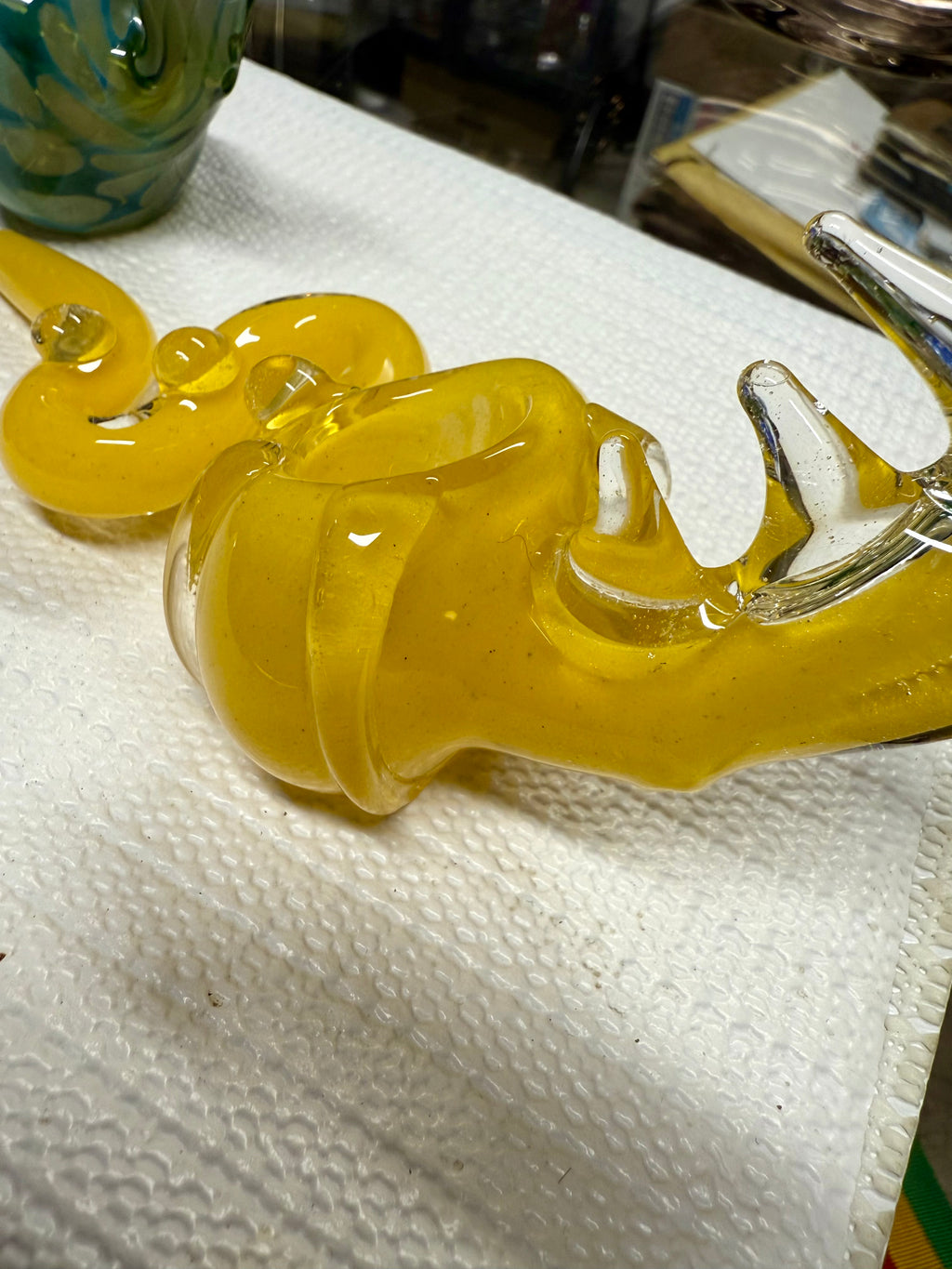 Close-up of Ripkitty 5" COBRA glass pipe bowl — cobra head sculpt with open chamber, yellow color