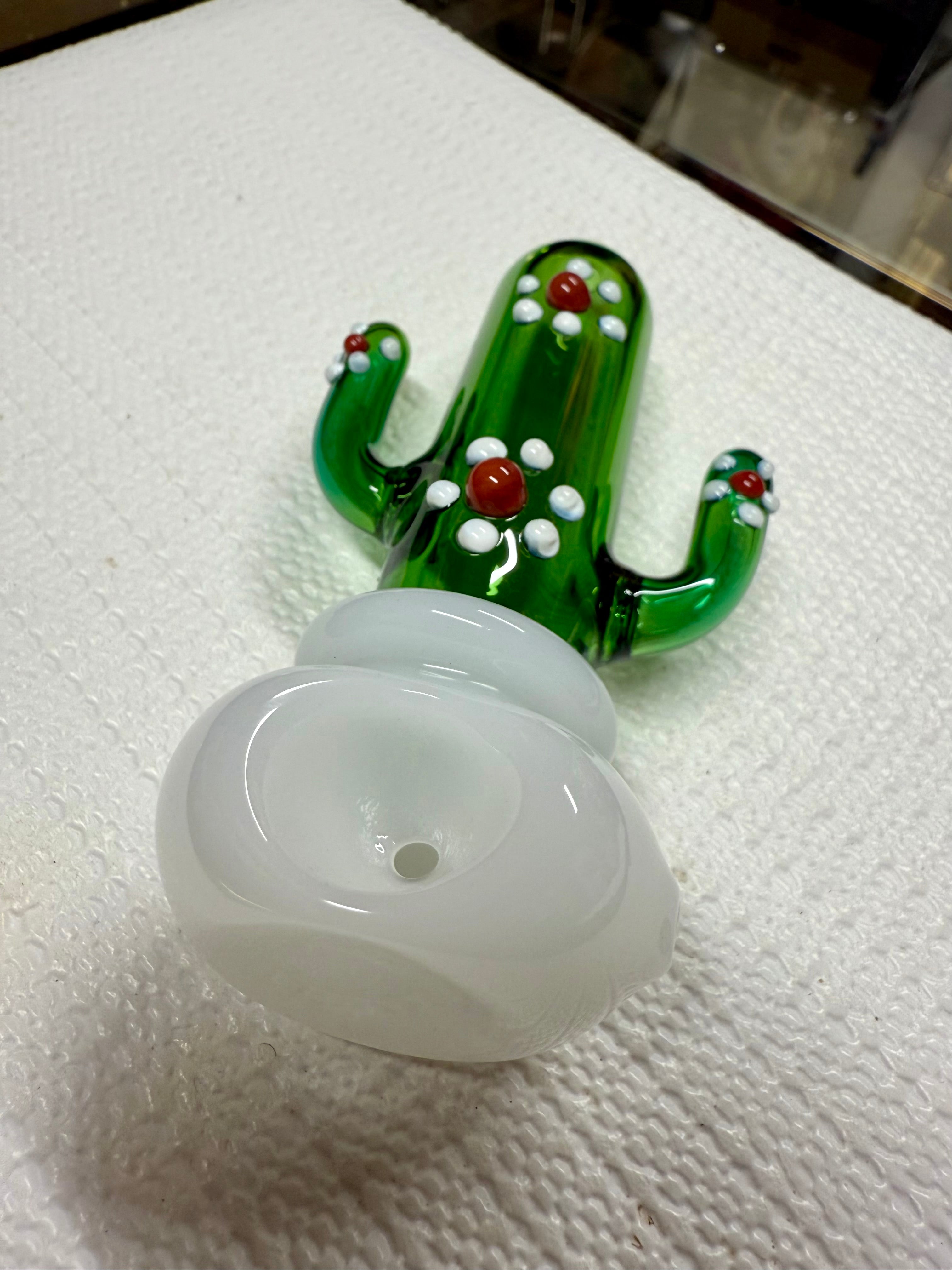 Ripkitty 4.5" cactus glass spoon pipe — green saguaro cactus body with white dot nodules and red bead accents, side profile showing full pipe length with milky white bowl, white background
