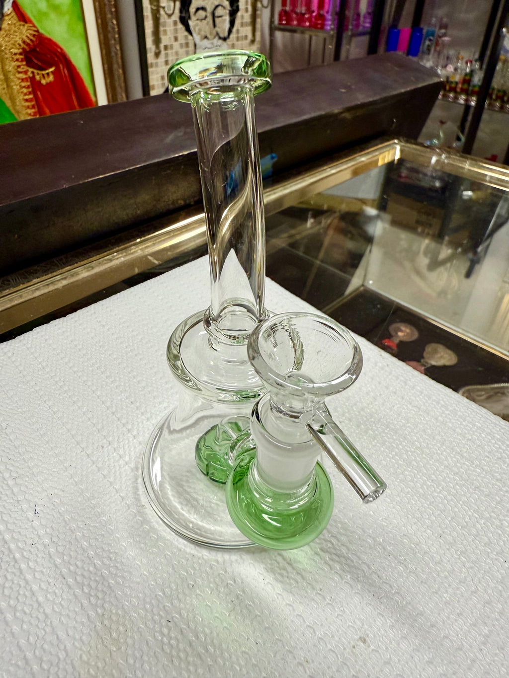 Ripkitty 7" conical bong — color shower neck, green base accent, angled overhead view showing mouthpiece, neck twist, and bowl joint