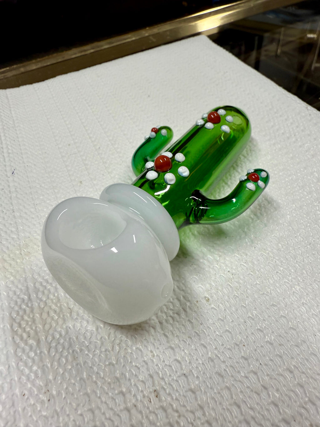 Ripkitty 4.5" cactus glass spoon pipe — green saguaro cactus body with white dot nodules and red bead accents, angled view of bowl end showing milky white opal bowl chamber, white background