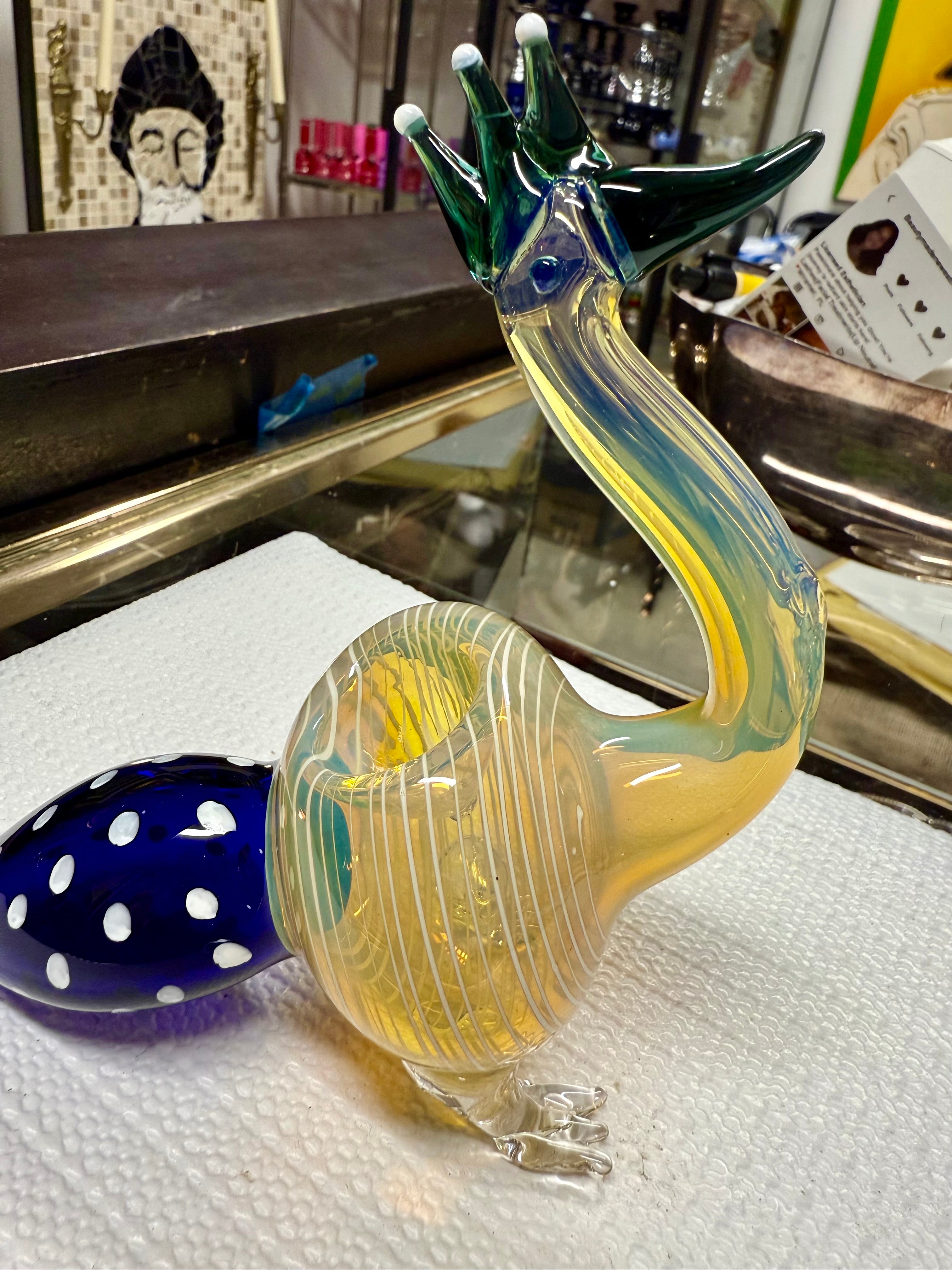 Ripkitty peacock art glass pipe — rear angle showing teal stripe pattern on yellow-amber body and sculpted glass feet