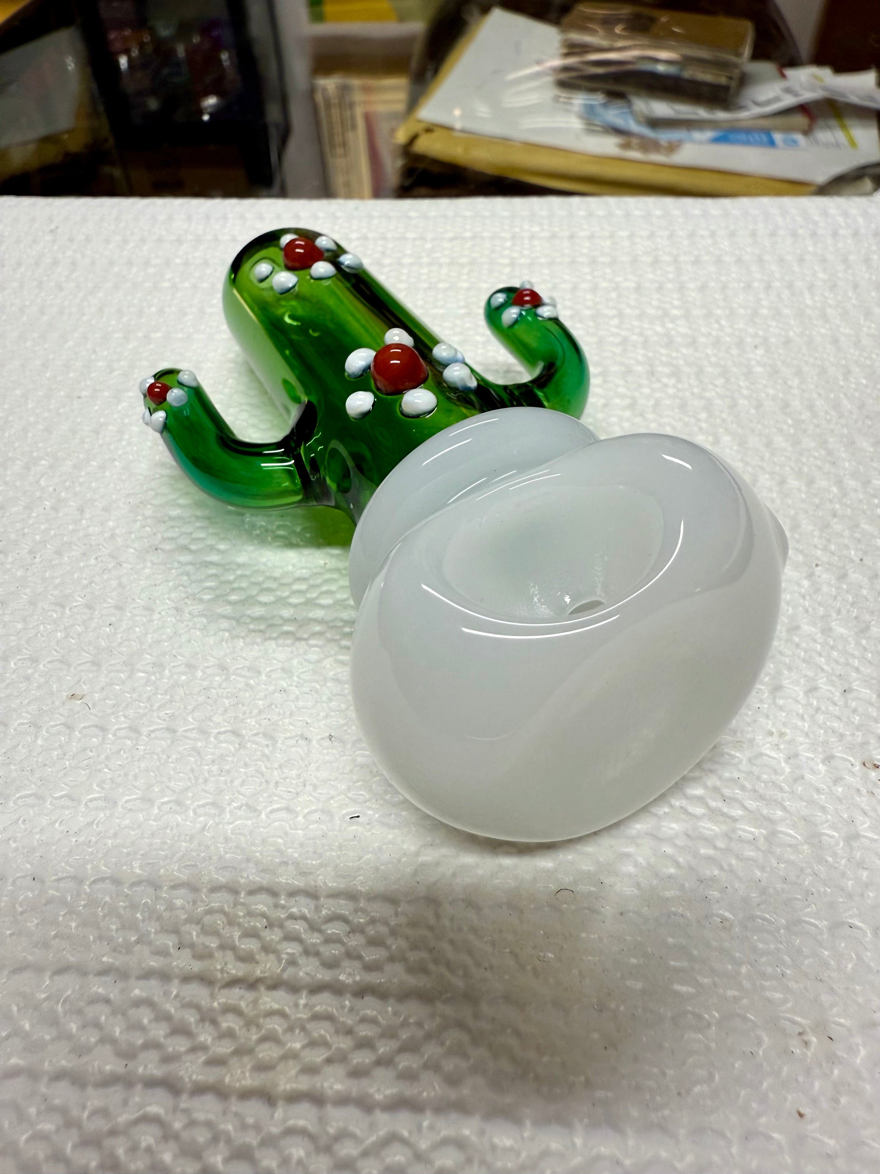 Ripkitty 4.5" cactus glass spoon pipe — green saguaro cactus body with white dot nodules and red bead accents, angled side view showing full pipe profile with milky white bowl, white background