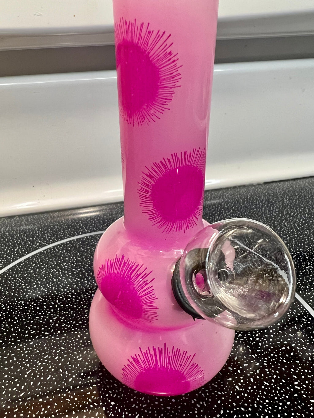 Ripkitty 5-inch soft glass water pipe, pink frosted finish with hot pink starburst print pattern, bowl piece inserted, side angle view