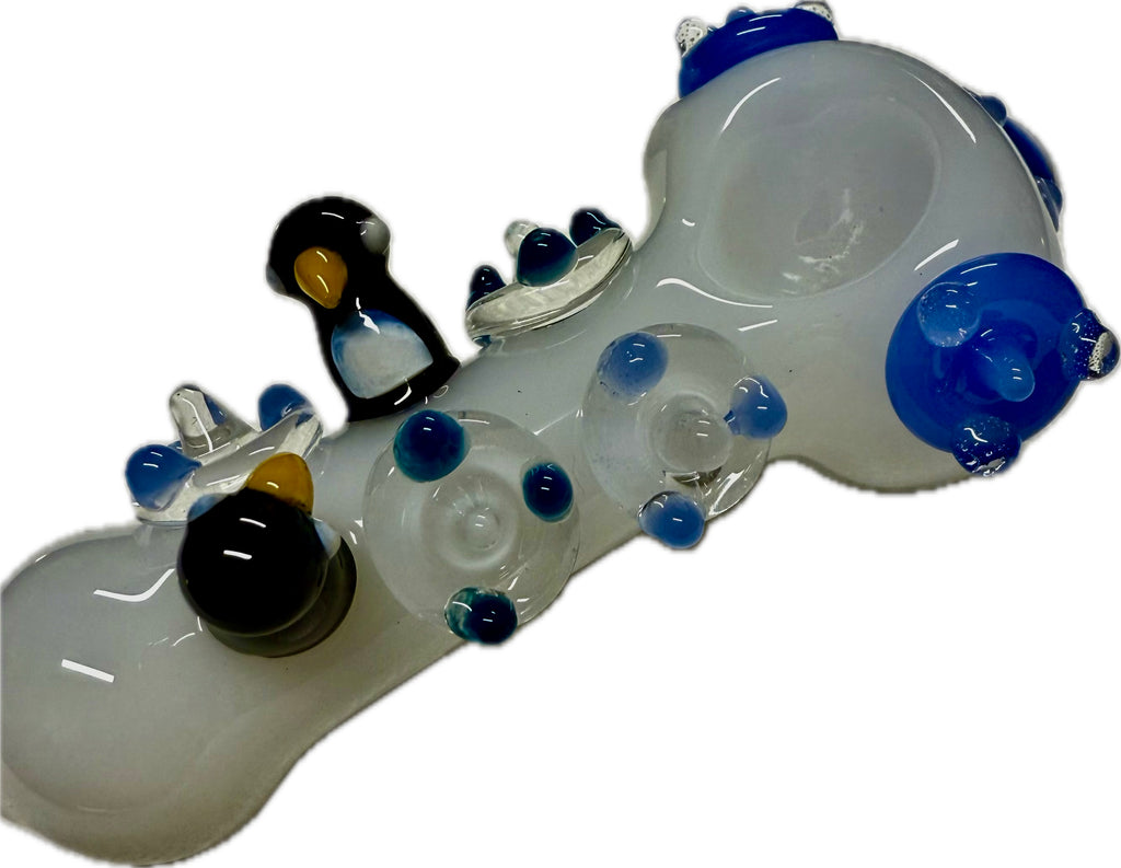 Ripkitty penguin art glass pipe — frosted clear with blue accents, side profile showing full pipe length with penguin sculpts and flipper accents
