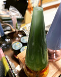 Close-up of Ripkitty 7" forest green cone showerhead water pipe with amber two-tone base, slate blue pipe visible in background