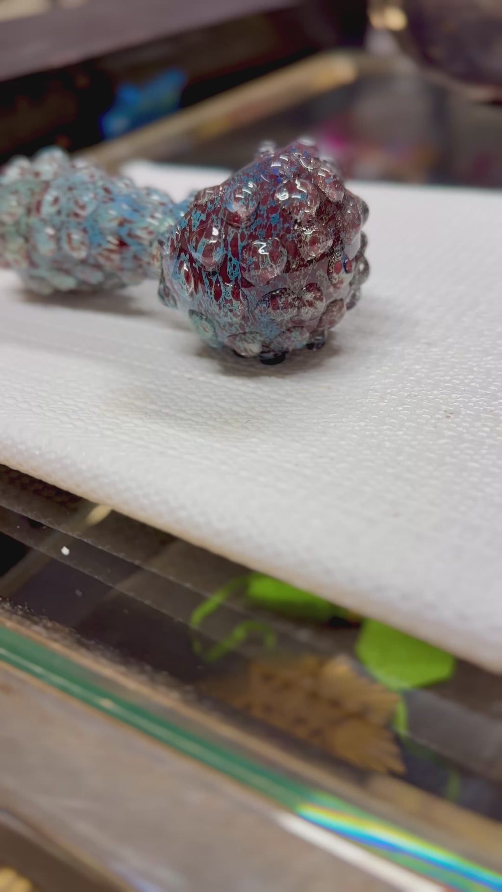 Ripkitty 5" blue spike borosilicate glass spoon pipe — 360° display video showing full-body raised bubble nodule texture, teal-blue and dark red frit pattern, deep rounded bowl, and bumpy mouthpiece end